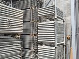 plusieurs piles de tuyaux en acier empilées dans un entrepôt