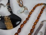 many different necklaces and bracelets on a table