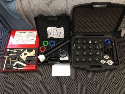 une mallette noire contenant des outils, posée par terre