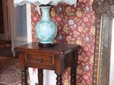 a small table with a lamp on it next to a mirror