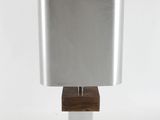 a close up of a lamp with a wooden base and a silver shade