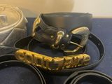 three belts that are sitting on a blue surface