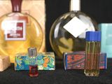several bottles of perfume are lined up on a black surface