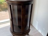 a small wooden cabinet with a glass door on top of a table