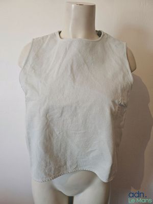 un mannequin portant un haut blanc, monté sur une tête de mannequin