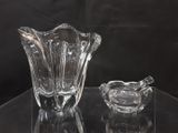 un vase en verre et un cendrier en verre posés sur une table