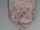 a close up of a purse with a blue ribbon hanging on a wall