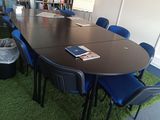 tables and chairs in a room with bookshelves and a green carpet