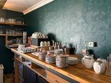 many plates and cups on the counter in the kitchen