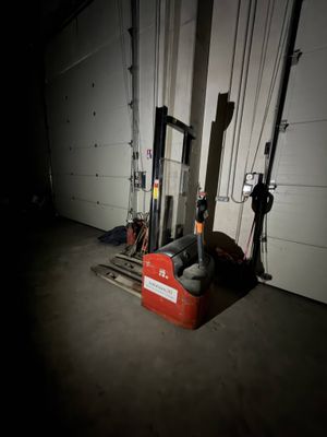 un chariot élévateur rouge dans un garage, la nuit