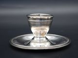 une tasse et une soucoupe en argent posées sur un plateau en argent