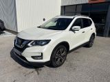 un SUV Nissan blanc garé devant un immeuble