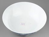 white and blue bowl on grey background with a red and white sticker on the side