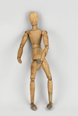 une image représentant un mannequin en bois posé sur une surface blanche