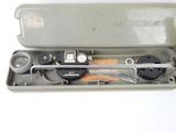 a metal box with tools inside of it on a white surface