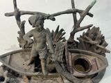 une statue représentant un garçon dans un bateau, posée sur une table