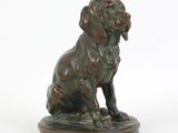 statue en bronze représentant un chien assis sur un socle en bois