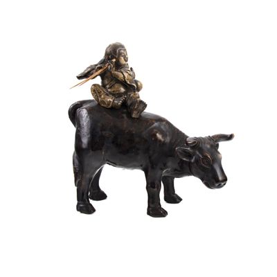 statue représentant un homme assis sur le dos d'une vache, sur le dos de laquelle se trouve un oiseau