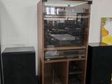 un meuble en bois équipé de haut-parleurs et surmonté d'une vitrine