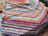 a close up of a blanket on a wooden table near a car