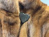 a close up of a fur coat with a heart on it