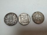 three silver coins sitting on top of a table next to each other
