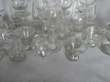 a lot of glassware on a table with a white table cloth