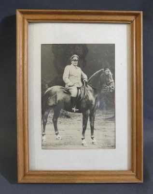 an old photo of a man riding a horse in a wooden frame