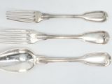 four forks and spoons are lined up on a white surface