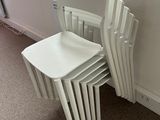 four white chairs sitting next to a window in a room