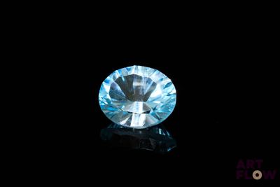 a close up of a blue diamond on a black surface