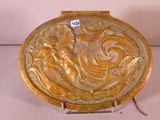 assiette en or décorée d'une sirène et de poissons, posée sur un socle