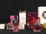 a lot of different perfume bottles on a black table