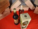 several bottles of wine are sitting on a table next to boxes of wine