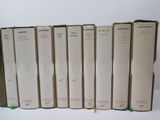 several books are lined up in a row on a white surface