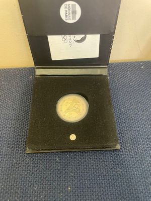 a gold coin in a black box on a blue carpet
