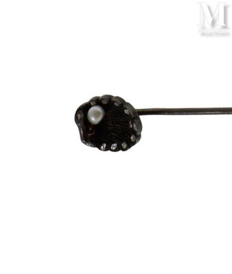 une photo en noir et blanc d'une broche ornée d'une perle
