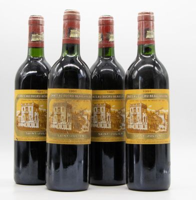 quatre bouteilles de vin sont alignées sur une surface blanche