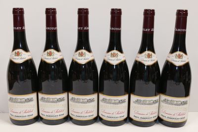 six bouteilles de vin sont alignées sur une table