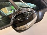 a close up of a car ' s side mirror with a car in the background