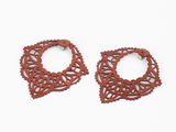 une paire de boucles d'oreilles rouges en bois sur fond blanc