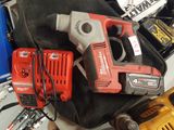 a corded drill and two other tools on a table