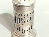 a silver salt shaker on a table with a white background