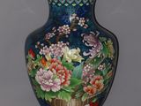 a blue vase with flowers on it sitting on a table