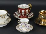 quatre tasses et soucoupes posées sur une surface noire