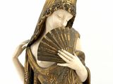 statue of a woman holding a fan and a fan in her hand