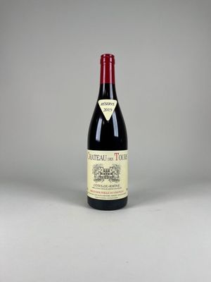 une bouteille de vin rouge posée sur une table blanche