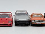 several toy cars are lined up in a row on a white surface