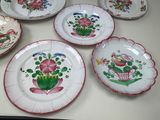 many plates with flowers on them on a table