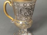 an image of a glass cup with a gold rim sitting on a table